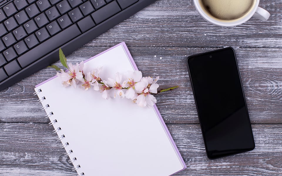 A notebook with a mobile phone & keyboard.